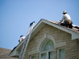 Workers installing new roof on a home